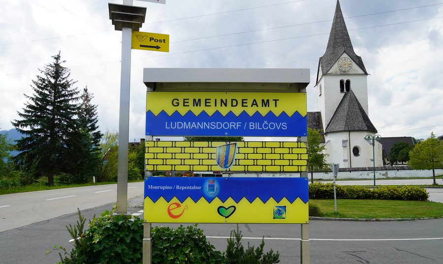 Informationstafel der Gemeinde Ludmannsdorf mit dem slowenischen Namen Bilčovs