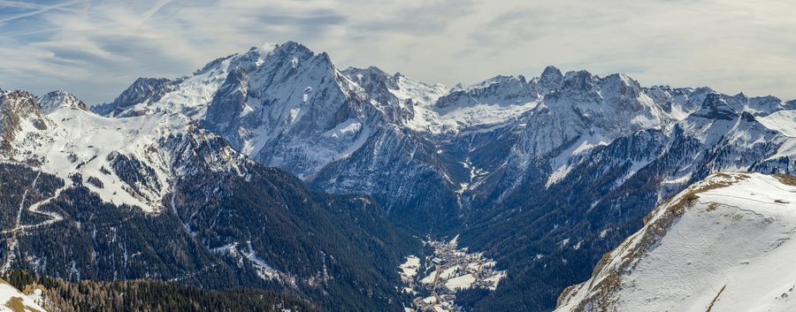Blick auf die Skigebiete Belvedere und Ciampac sowie die Dolomiten im Val di Fassa